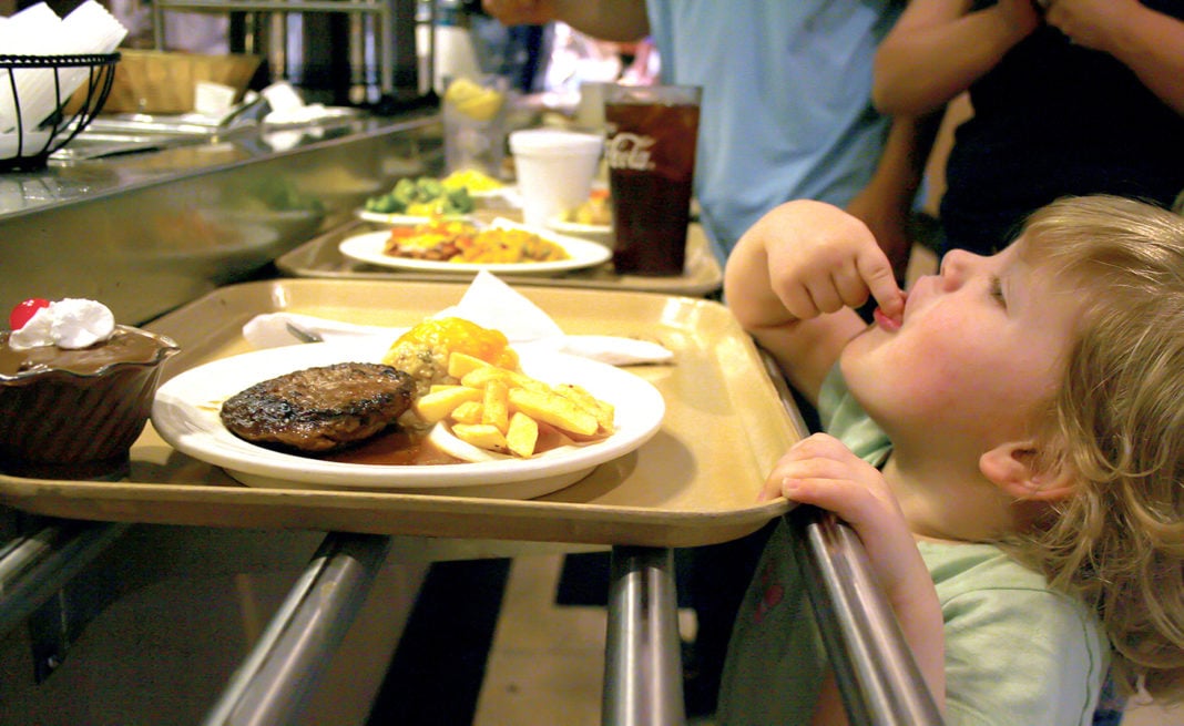 Lundy Grace, 2, sneaks a bite of her french fries in line at Piccadilly Wednesday night.