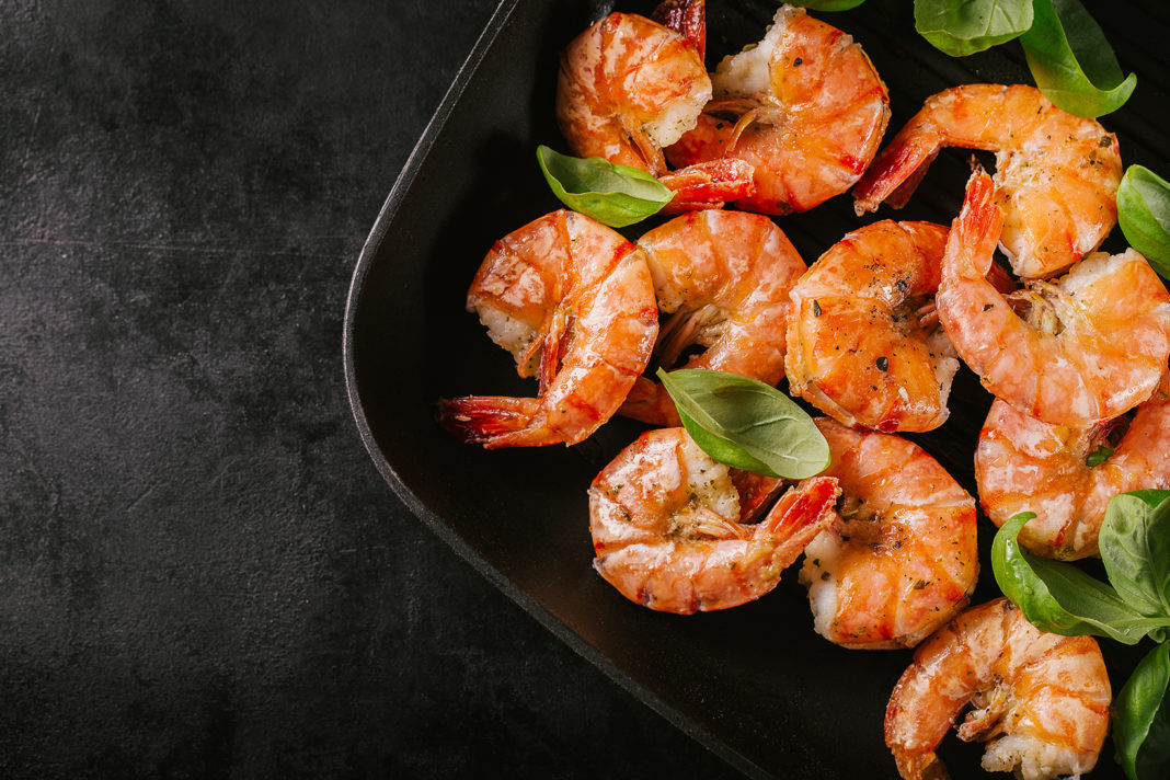 Grilled king prawns on pan on dark table shrimp