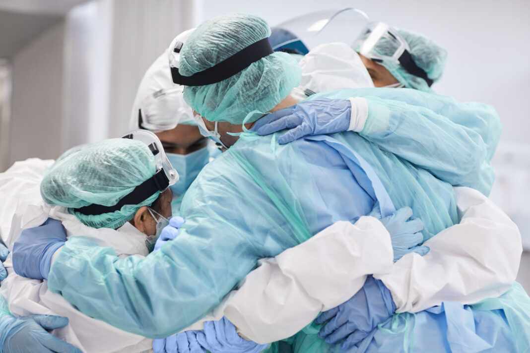 Doctors and nurses embracing each other during pandemic Health care